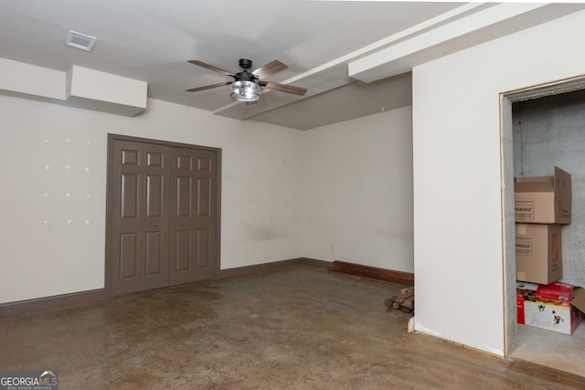 unfurnished room with ceiling fan and concrete flooring