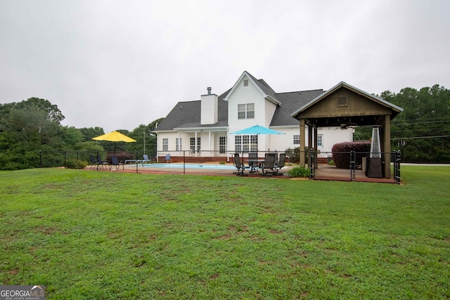 back of house with a lawn, ceiling fan, and a patio area