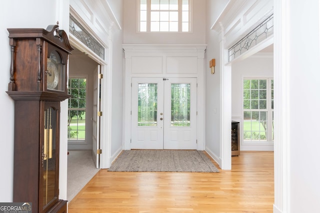 entryway with a healthy amount of sunlight, light hardwood / wood-style flooring, and a high ceiling