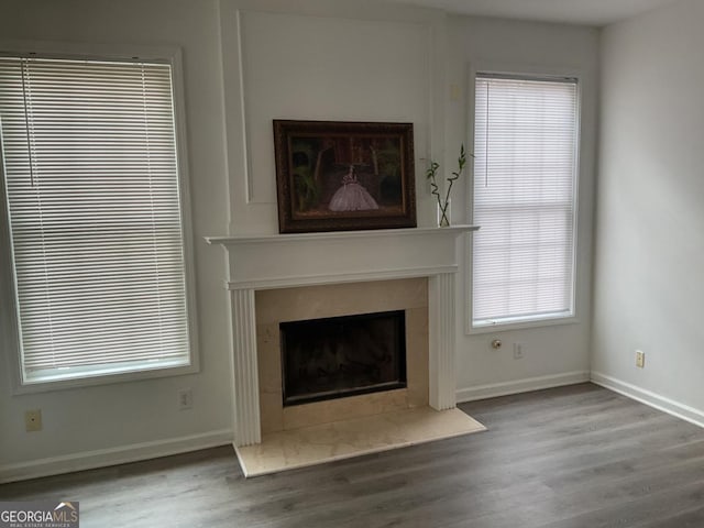 unfurnished living room featuring hardwood / wood-style flooring and a high end fireplace