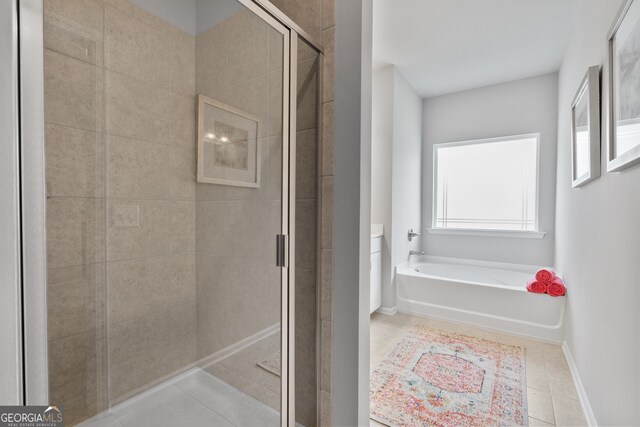 bathroom with tile patterned floors and shower with separate bathtub