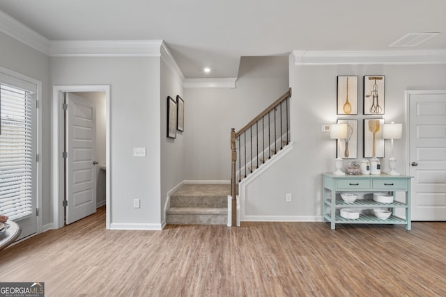 foyer featuring ornamental molding and light hardwood / wood-style flooring