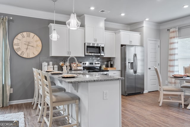 kitchen with pendant lighting, sink, appliances with stainless steel finishes, white cabinets, and stone countertops