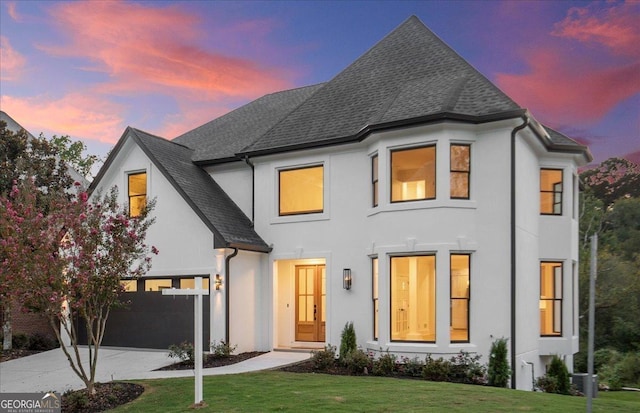 view of front of house featuring a garage and a lawn