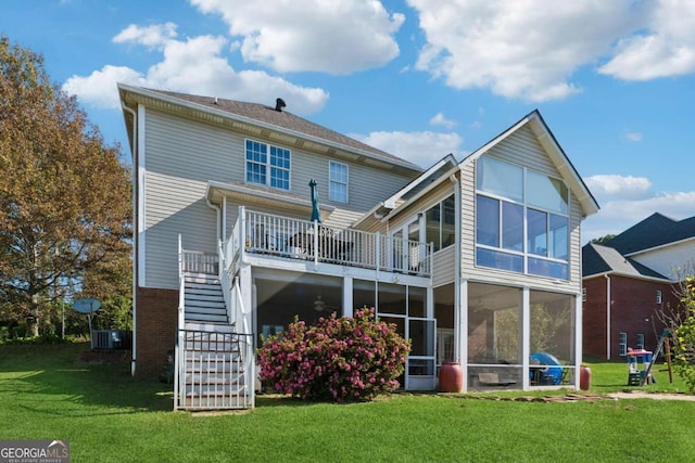 back of house featuring a lawn and a sunroom