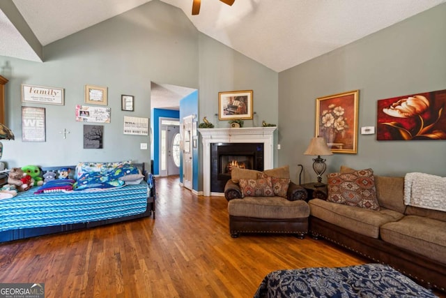 living room with wood-type flooring, high vaulted ceiling, and ceiling fan