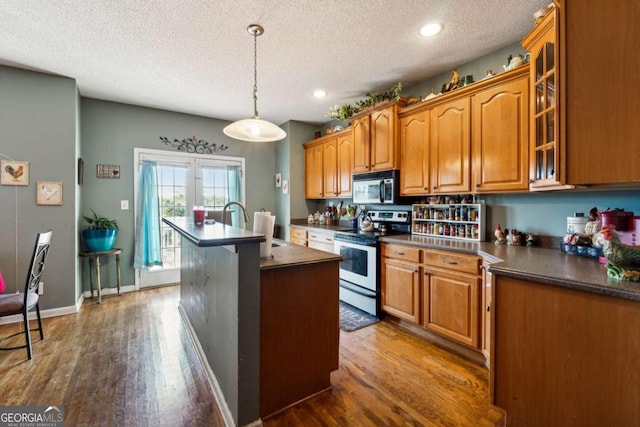 kitchen with sink, stainless steel electric range, a textured ceiling, dark hardwood / wood-style floors, and pendant lighting