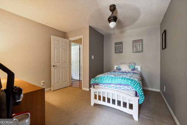 carpeted bedroom featuring ceiling fan and a textured ceiling