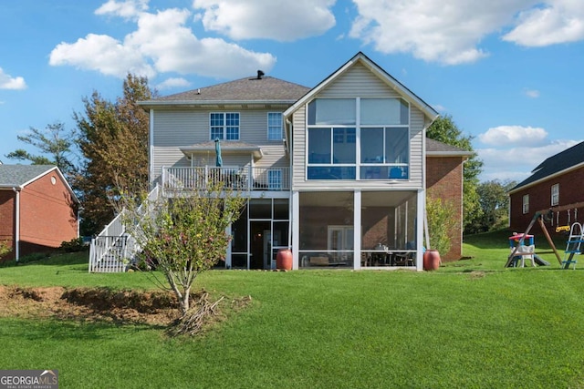 rear view of house with a yard and a sunroom