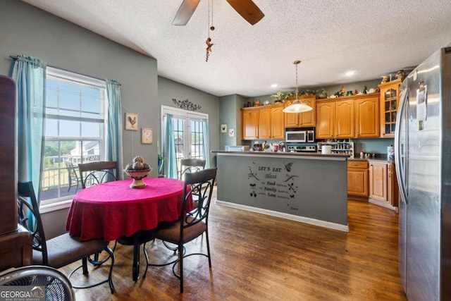 dining area with dark wood-type flooring, a textured ceiling, and ceiling fan