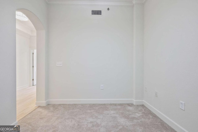 unfurnished room with crown molding and light carpet