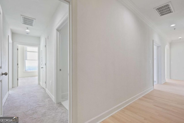 hall with crown molding and light hardwood / wood-style floors