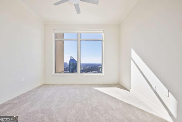 carpeted spare room featuring crown molding and ceiling fan