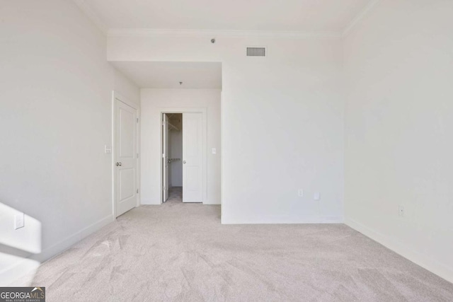 carpeted spare room featuring crown molding