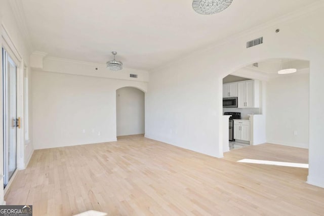 empty room featuring ornamental molding and light hardwood / wood-style floors