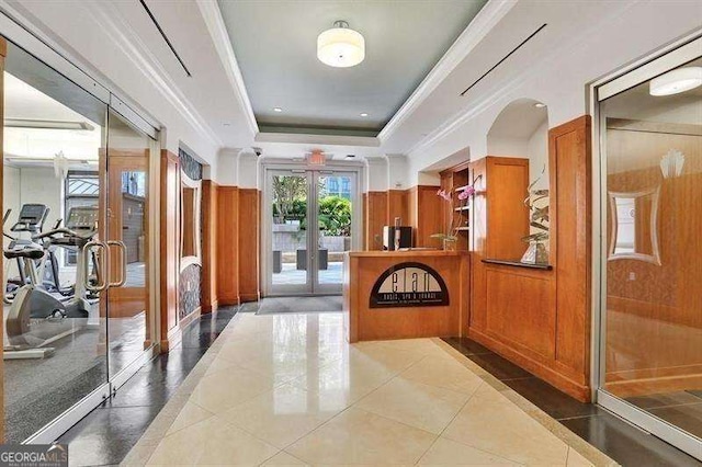 hall featuring french doors, tile patterned floors, ornamental molding, and a raised ceiling