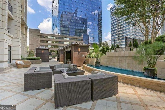 view of patio with an outdoor living space with a fire pit and a shed