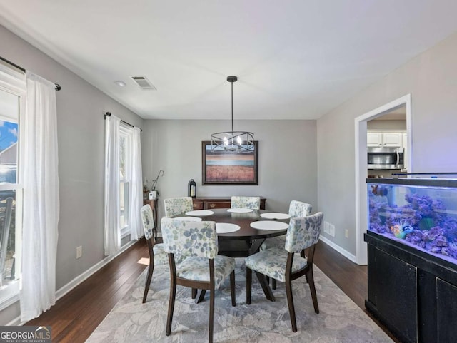 dining room featuring a notable chandelier and dark hardwood / wood-style flooring