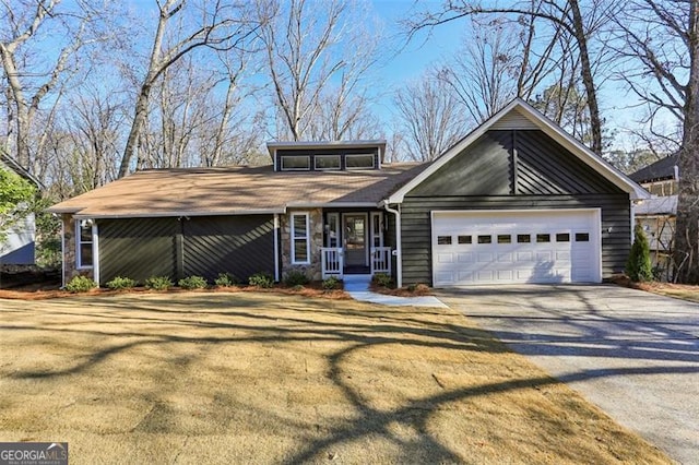 view of front facade featuring a garage, a porch, and a front yard