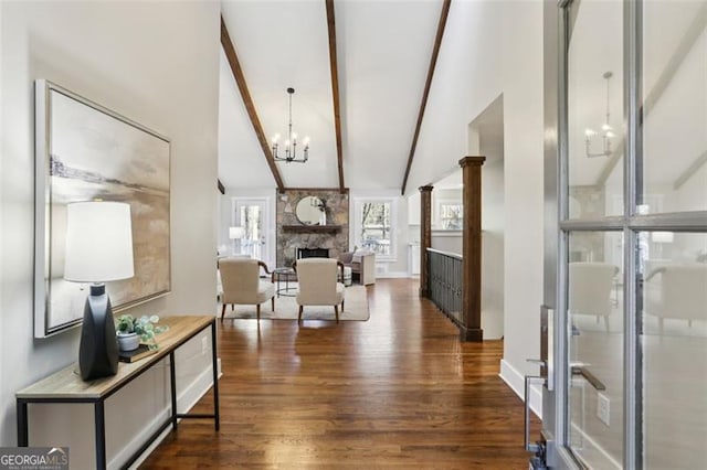 interior space with high vaulted ceiling, dark hardwood / wood-style floors, a notable chandelier, a fireplace, and beamed ceiling