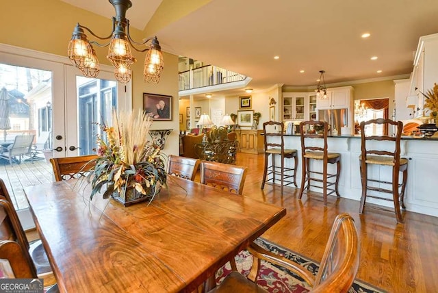 dining area with hardwood / wood-style floors, crown molding, plenty of natural light, and french doors