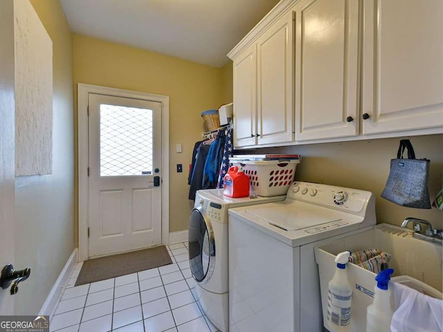 laundry area featuring cabinets, washing machine and clothes dryer, sink, and light tile patterned floors