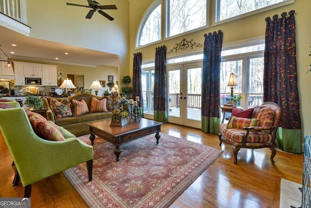 living room featuring light hardwood / wood-style floors, french doors, and a healthy amount of sunlight