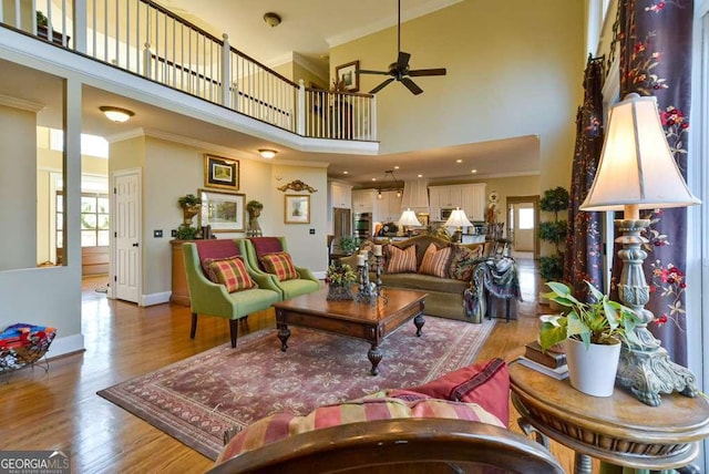 living room featuring hardwood / wood-style floors, crown molding, plenty of natural light, and ceiling fan