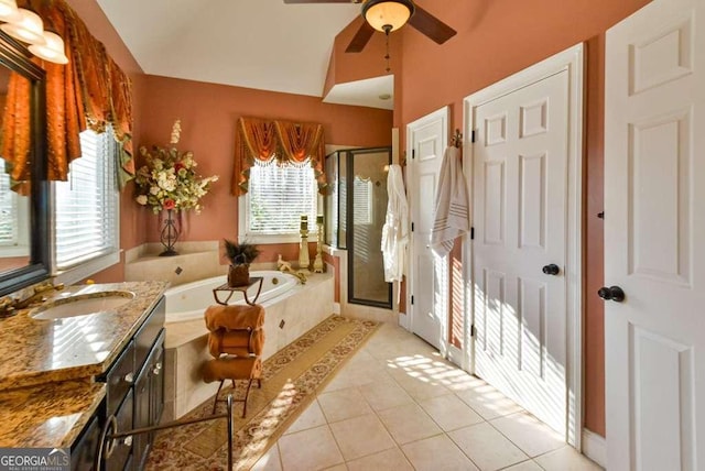 bathroom with lofted ceiling, tile patterned floors, shower with separate bathtub, vanity, and ceiling fan