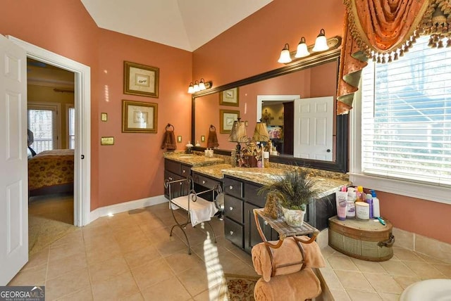 bathroom featuring vanity, lofted ceiling, and tile patterned floors