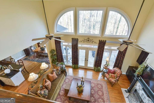 living room with hardwood / wood-style flooring, a wealth of natural light, french doors, and ceiling fan