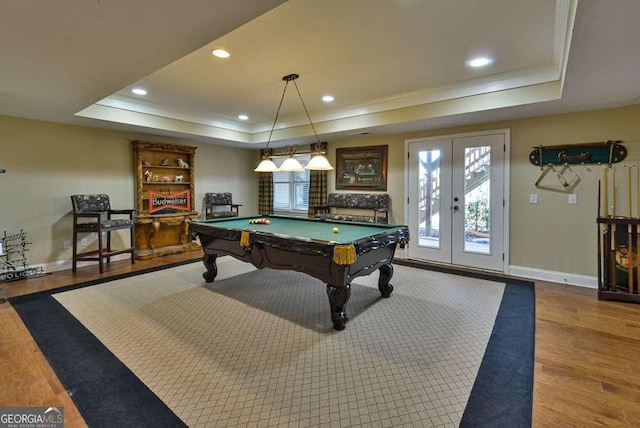 recreation room featuring a tray ceiling, pool table, french doors, and light wood-type flooring