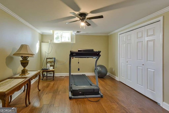 workout room featuring wood-type flooring, ornamental molding, and ceiling fan