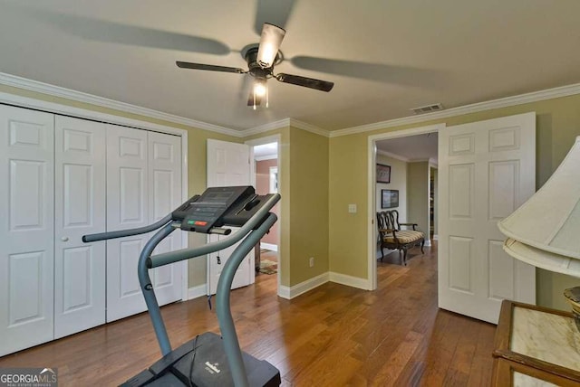 workout area featuring crown molding, dark wood-type flooring, and ceiling fan