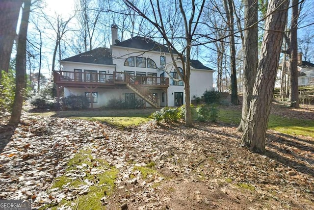 rear view of property featuring a yard and a deck