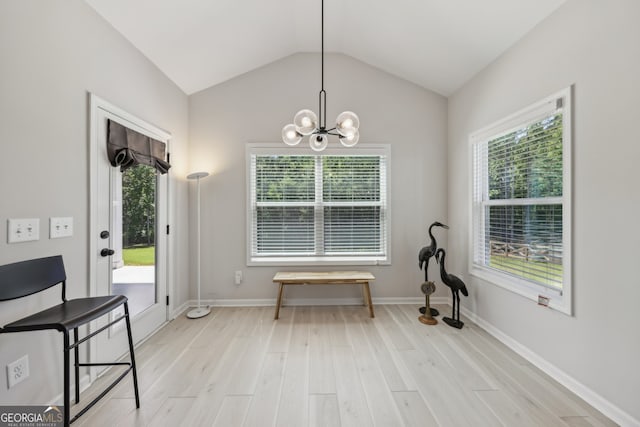 dining area with vaulted ceiling, a notable chandelier, light wood-type flooring, and a wealth of natural light