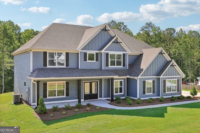 craftsman-style house with central AC unit, a front lawn, and french doors