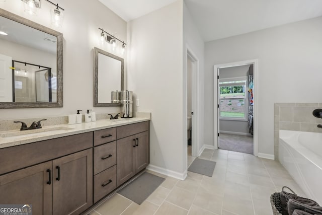 bathroom with a tub to relax in, vanity, toilet, and tile patterned flooring