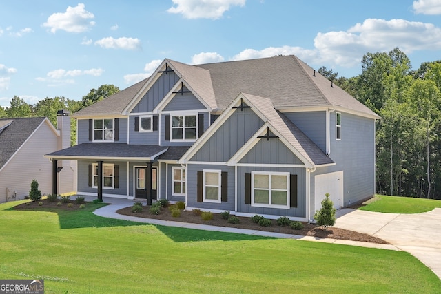 view of front of property with a garage, a front lawn, and a porch