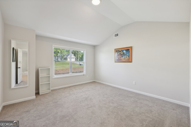 unfurnished room with lofted ceiling and carpet flooring