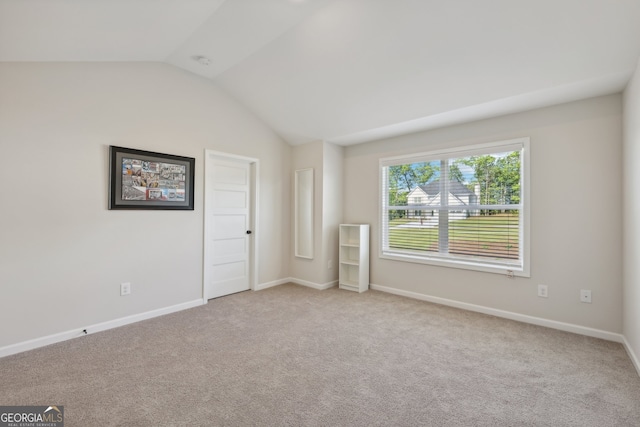 carpeted empty room featuring lofted ceiling