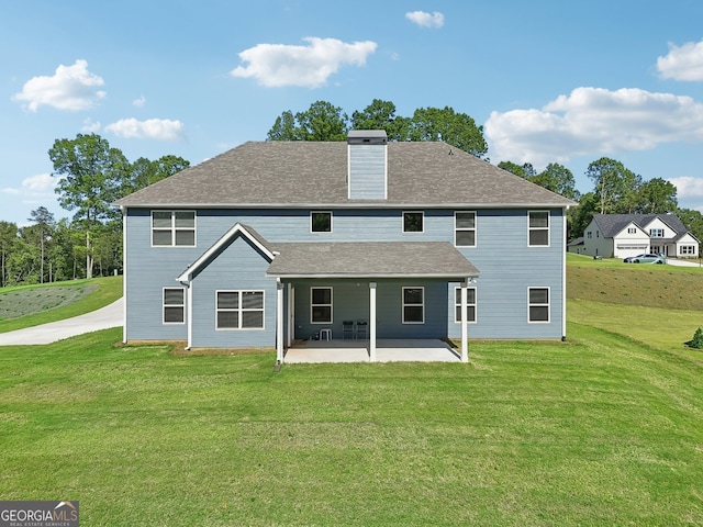 rear view of property with a patio and a yard