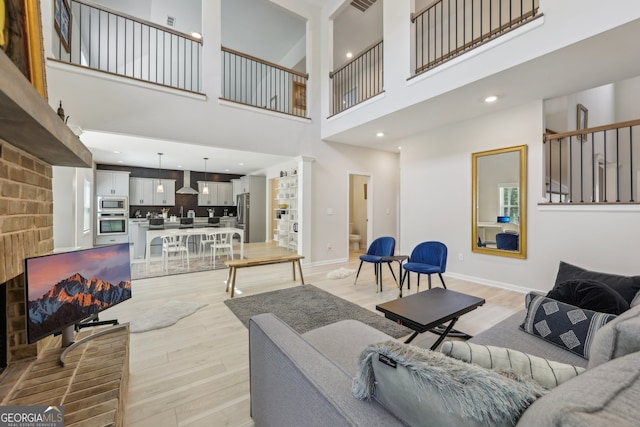 living room with light hardwood / wood-style floors and a high ceiling