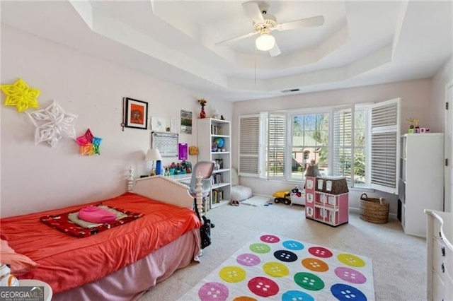 bedroom featuring carpet floors, a raised ceiling, and ceiling fan