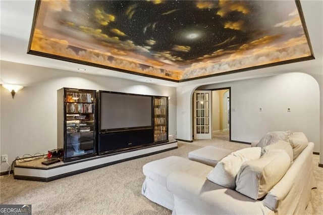 cinema featuring light carpet and a raised ceiling