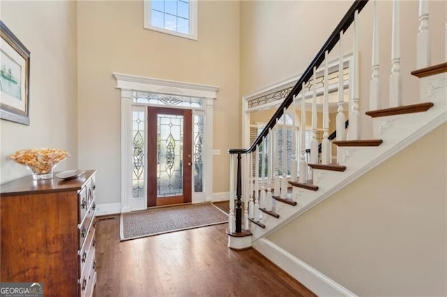 foyer featuring dark hardwood / wood-style flooring and a towering ceiling