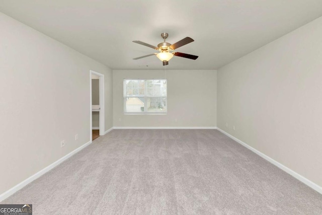 spare room with ceiling fan and light colored carpet