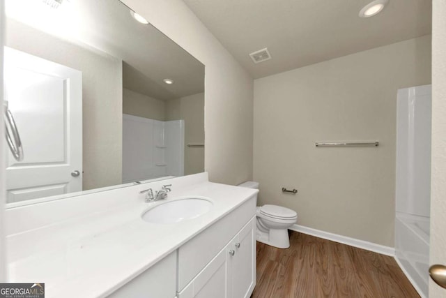 full bathroom featuring hardwood / wood-style flooring, shower / bathtub combination, vanity, and toilet