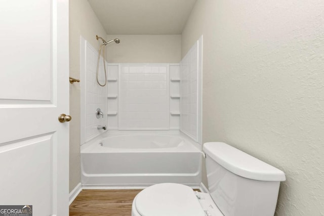 bathroom with shower / bathtub combination, wood-type flooring, and toilet