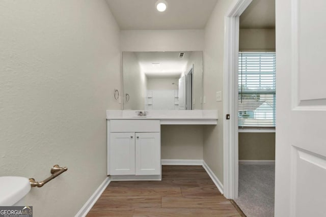 bathroom featuring vanity, toilet, and hardwood / wood-style floors